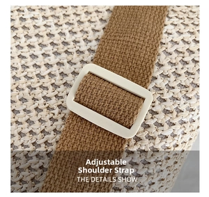 Detail showing the adjustable brown fabric shoulder strap and white resin buckle