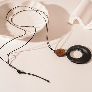 Minimalist resin and wood geometric long necklace on a white ceramic display