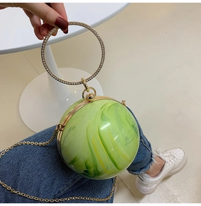 Detail of green marble acrylic sphere bag with rhinestone handle and gold chain strap