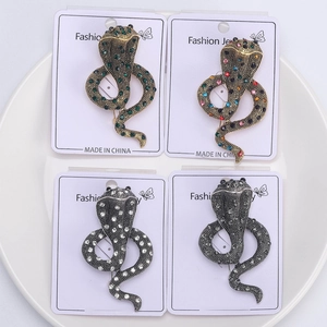 Detail of four colorful snake brooches with rhinestones on a jewelry display card