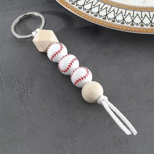 Close-up of baseball wooden bead keychain with geometric beads and white cotton tassel