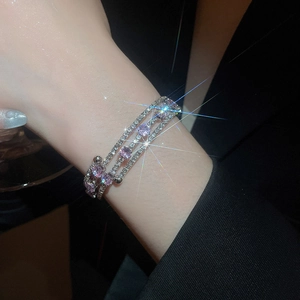 Detail of a three-layer zircon wrap bracelet with purple stones on a model wrist