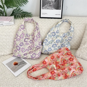 Detailed texture of assorted floral canvas tote bags displayed on a white sofa