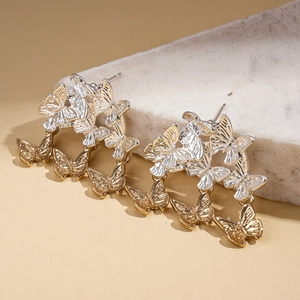 Détail de boucles d'oreilles papillon bicolores avec textures métalliques complexes