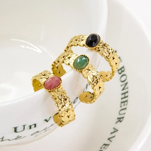 Titanium steel open rings with pink green and black oval gemstones on a white cup rim