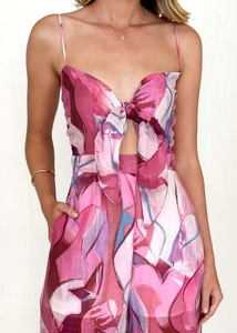 Close-up of floral print romper featuring front bow tie and waist cutout detail