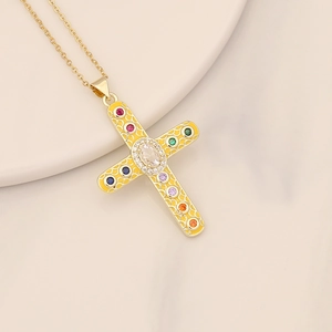 Detailed macro view of a gold cross pendant with colorful zircon stones and textures