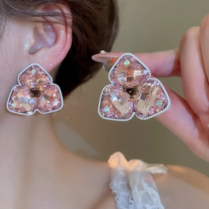 Makroaufnahme pinker Kristall-Ohrstecker in Blumenform mit silberner Kordelrand