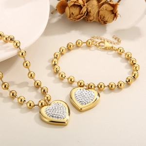 Gold-plated stainless steel jewelry set featuring a sparkling pavé heart necklace and bracelet