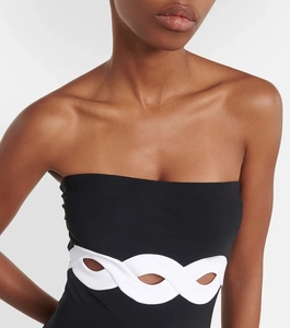 Detail of black cutout swimsuit featuring decorative white chain links at the waistline