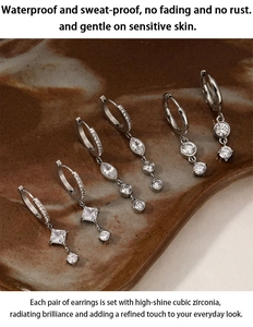 Detailed view of silver stainless steel zirconia drop earrings on a ceramic dish