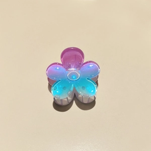 Detailed view of mini frangipani hair claw with purple and blue aurora gradient finish