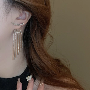 Close-up of tiered rhinestone fringe earrings on model showcasing layered sparkle