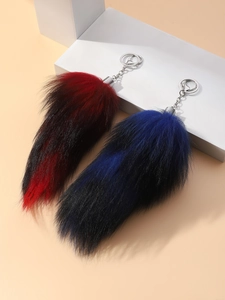 Close-up of fluffy faux fur fox tail charms in red and blue gradient with silver clasps
