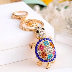 Close-up of golden metal turtle keychain featuring colorful rhinestones and crystal details