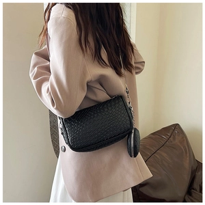 Detailed view of black crocodile pattern crossbody bag with wide strap and round coin purse