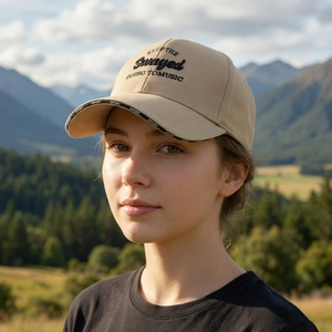 Beige outdoor baseball cap with embroidery and long brim shown in scenic mountain view