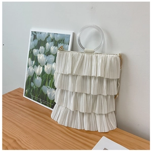 Detail of white tiered pleats and transparent acrylic handle on the tote bag