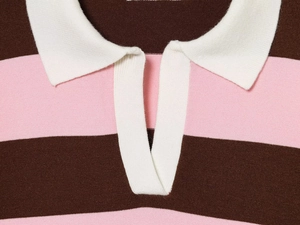 Detail of white polo collar and striped knit fabric with brown and pink patterns