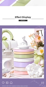 Vertical stack of multi-colored polyester cotton satin ribbons on white spools in a fresh setting