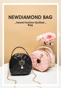 Close-up of quilted round bags in black and pink with golden cat charms and chain straps