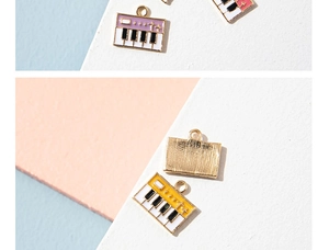 Macro detail of alloy piano keyboard pendants with pink and yellow enamel finish