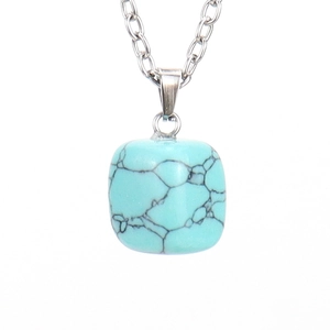 Macro detail of turquoise square pendant with black veins and silver chain loop