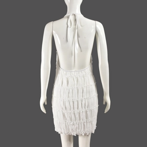 Detail view of the layered ruffles and backless design on a white halter mini dress