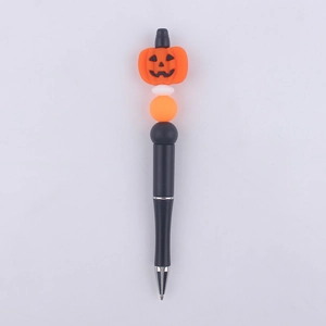 Close-up of a black beaded pen featuring a silicone Halloween pumpkin topper and beads