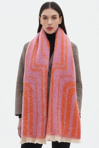 Detail showing pink and orange geometric jacquard knit scarf with fringe edges and soft texture