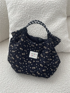 Floral canvas tote bag with woven handles and magnetic closure on cozy background