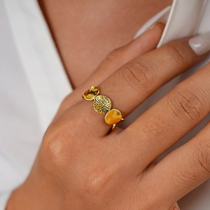 Detailaufnahme eines goldenen geometrischen Rings mit Hammerschlag-Optik und Polierung