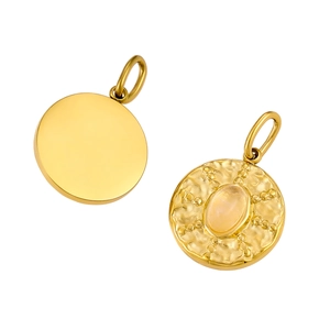 Detail of vintage round gold pendant with hammer texture and oval gemstone inlay