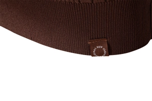 Macro shot of dark brown knit sweater hem featuring vertical ribbed texture and fashion label