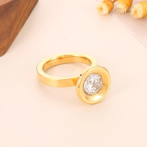 Détail de la bague large en acier titane doré ornée d'un grand zircon rond brillant