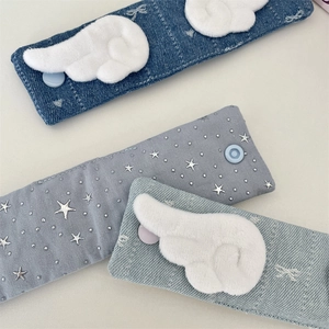 Macro detail of fabric cable organizers with plush feather applique and silver star patterns