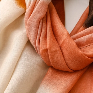 Detailed macro texture of a thin woven scarf featuring a soft orange gradient transition