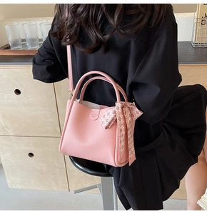 Pink lychee texture bucket bag with plaid silk scarf detail and fashion bag label