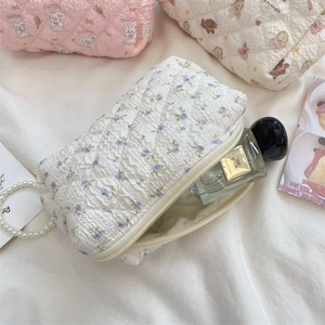 Gesteppte Stofftaschen mit Blumen-, Hasen- und Bärenmustern im Makro-Detail