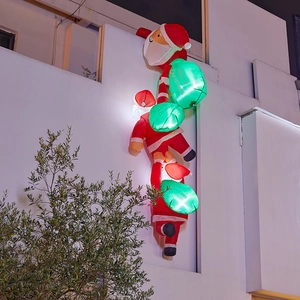 Outdoor inflatable Christmas climbing Santas with glowing gift bags on a building wall