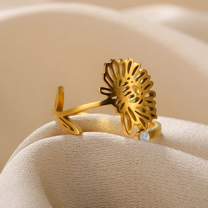 Macro detail of golden sunflower open ring with zircon on smooth silk fabric