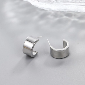Macro shot of silver-tone C-shape hoop earrings with high-polish finish and water-ripple shadow