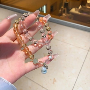 Detailed shot of beaded crystal bracelet with chalcedony, quartz and a blue gourd charm