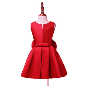 Detail of red satin flower girl dress showing V-neckline, bow waist and pleated skirt