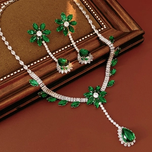 Detailed macro view of heavy zircon flower jewelry set with emerald drop pendant