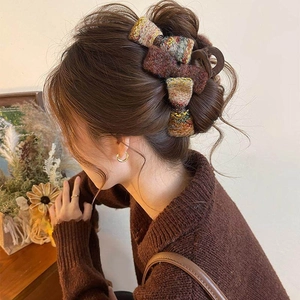 Détail d'une grande pince à cheveux en résine avec trois nœuds en tweed multicolore