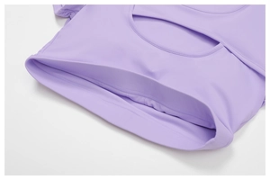 Dettaglio maglia da yoga viola chiaro con design traforato e finitura a doppia cucitura