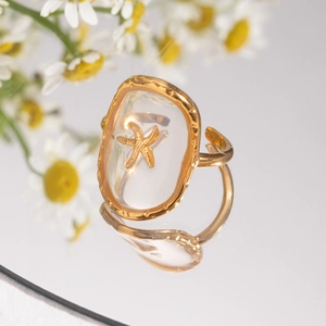 Golden starfish open ring with transparent resin detailing on a mirror surface