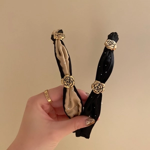 Elegant camellia headband set in beige and black silk with gold floral and rhinestone details