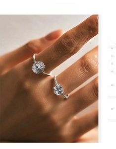 Close-up of stacked S925 silver rings with oval and cushion cut halo sparkling diamonds